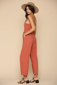 Brick color semi cropped jumpsuit with button & waist ribbon detail and adjustable straps. Cotton blend.