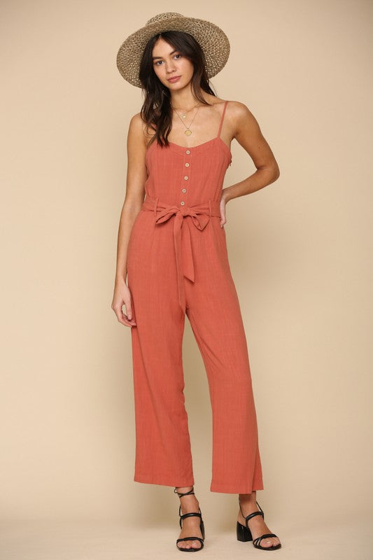 Brick color semi cropped jumpsuit with button & waist ribbon detail and adjustable straps. Cotton blend.