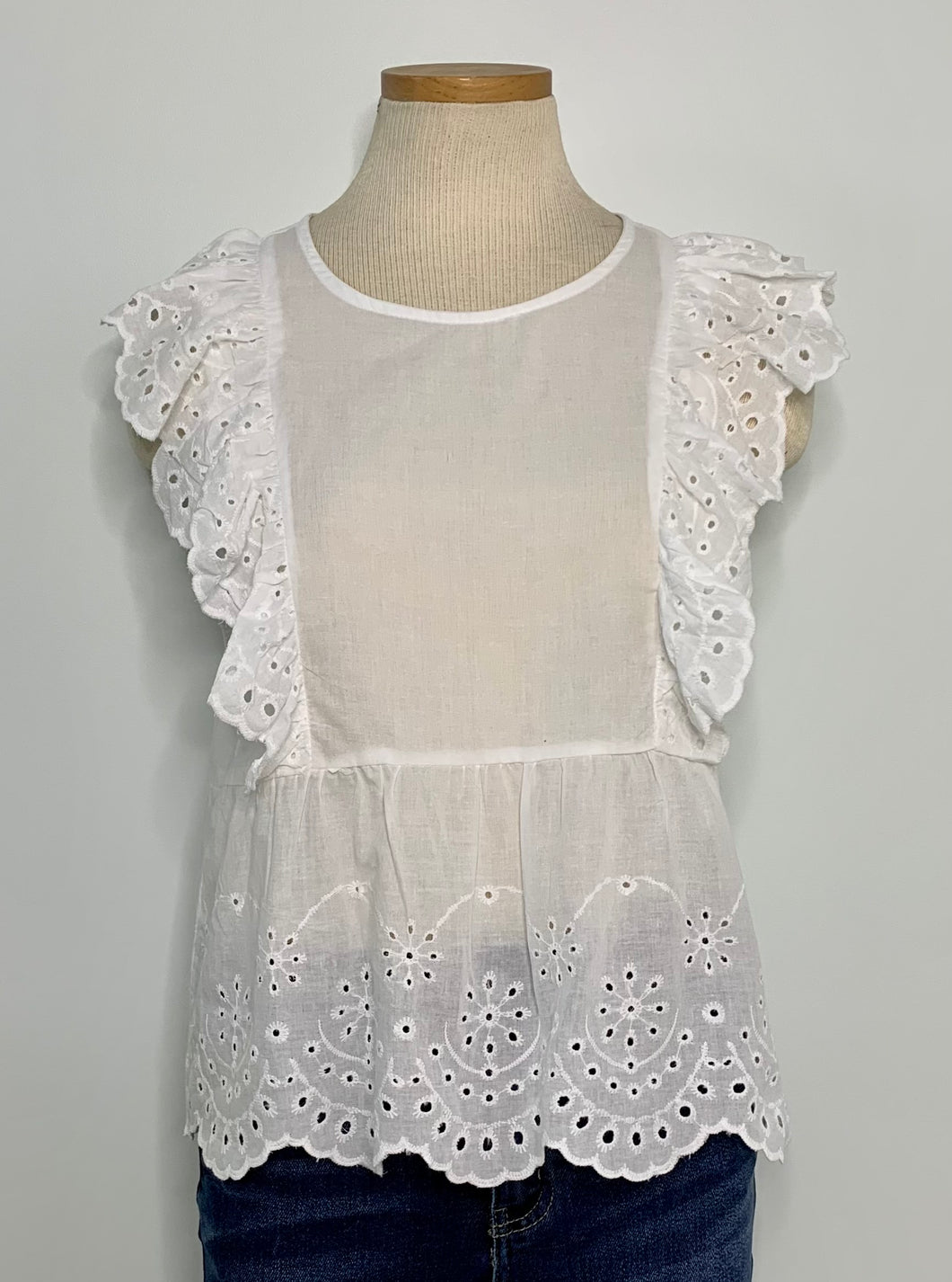 White lightweight top with eyelet & ruffle detail. 100% Cotton.