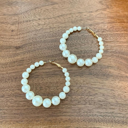 Gradual pearl hoops with gold clasp detail.